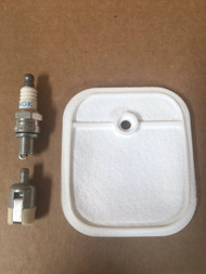 Redmax trimmer tune up kit includes white felt air filter with rubber sides and off-center mounting hole, NGK spark plug, and Walbro felt fuel filter with metal band.